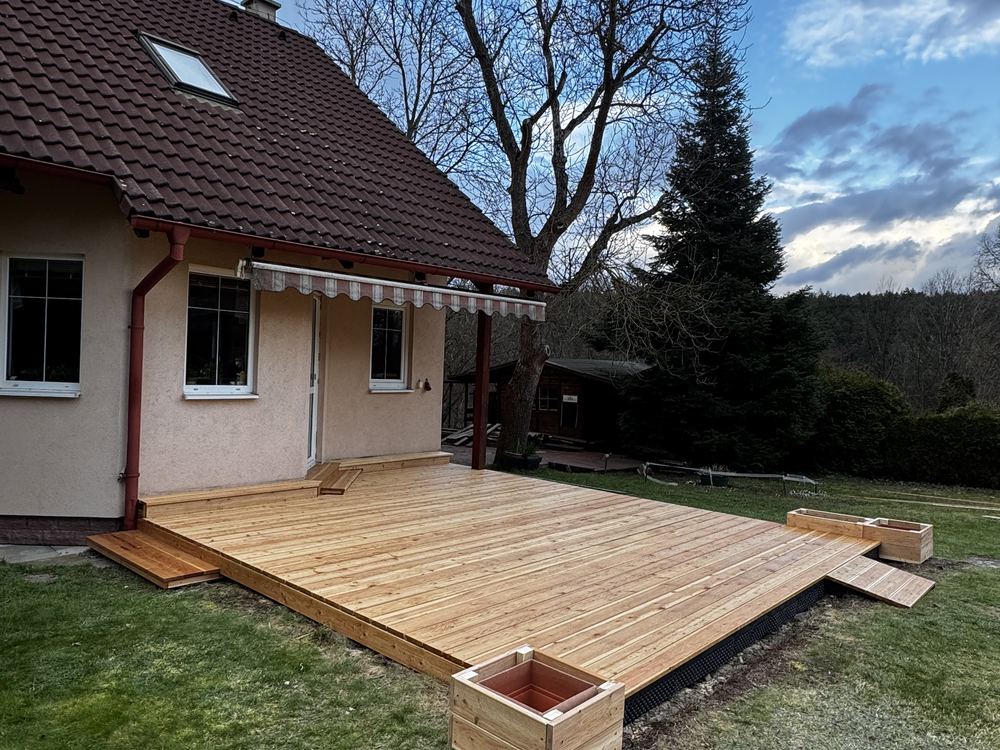 Terasa z dřevěných prken s truhlíky a markýzou