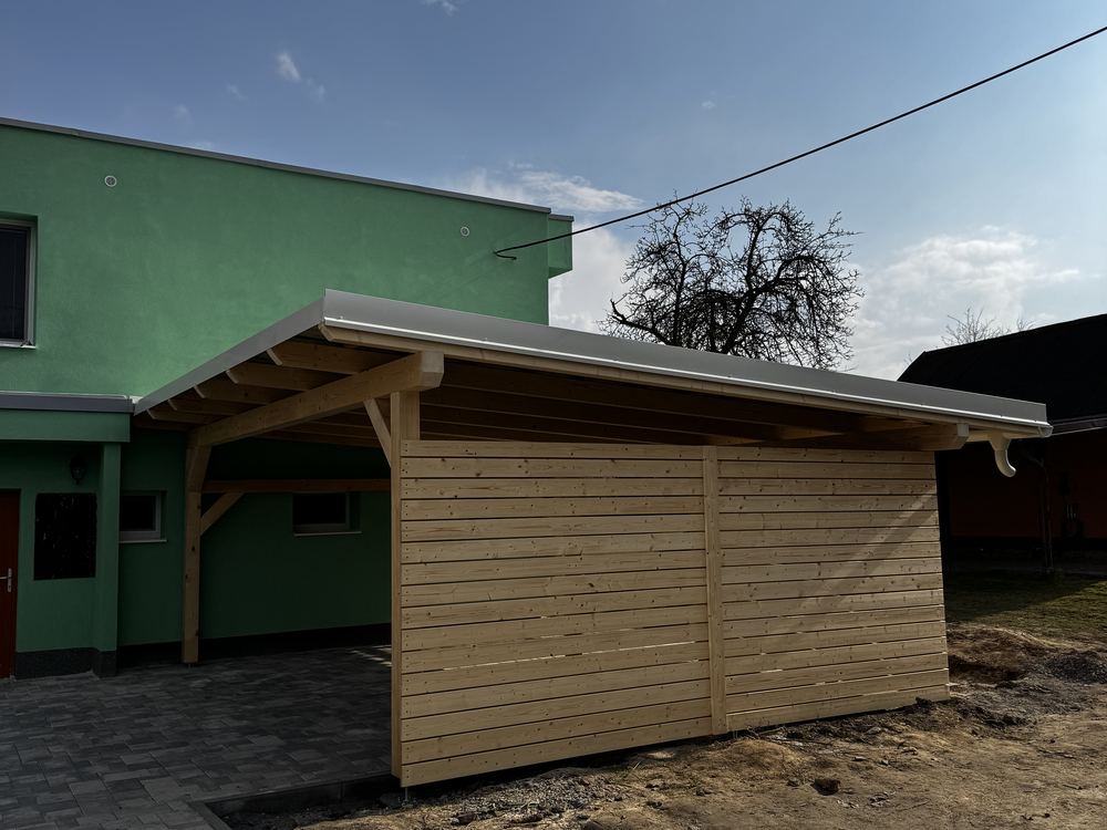 Dřevěný carport přistavěný k zelené fasádě domu
